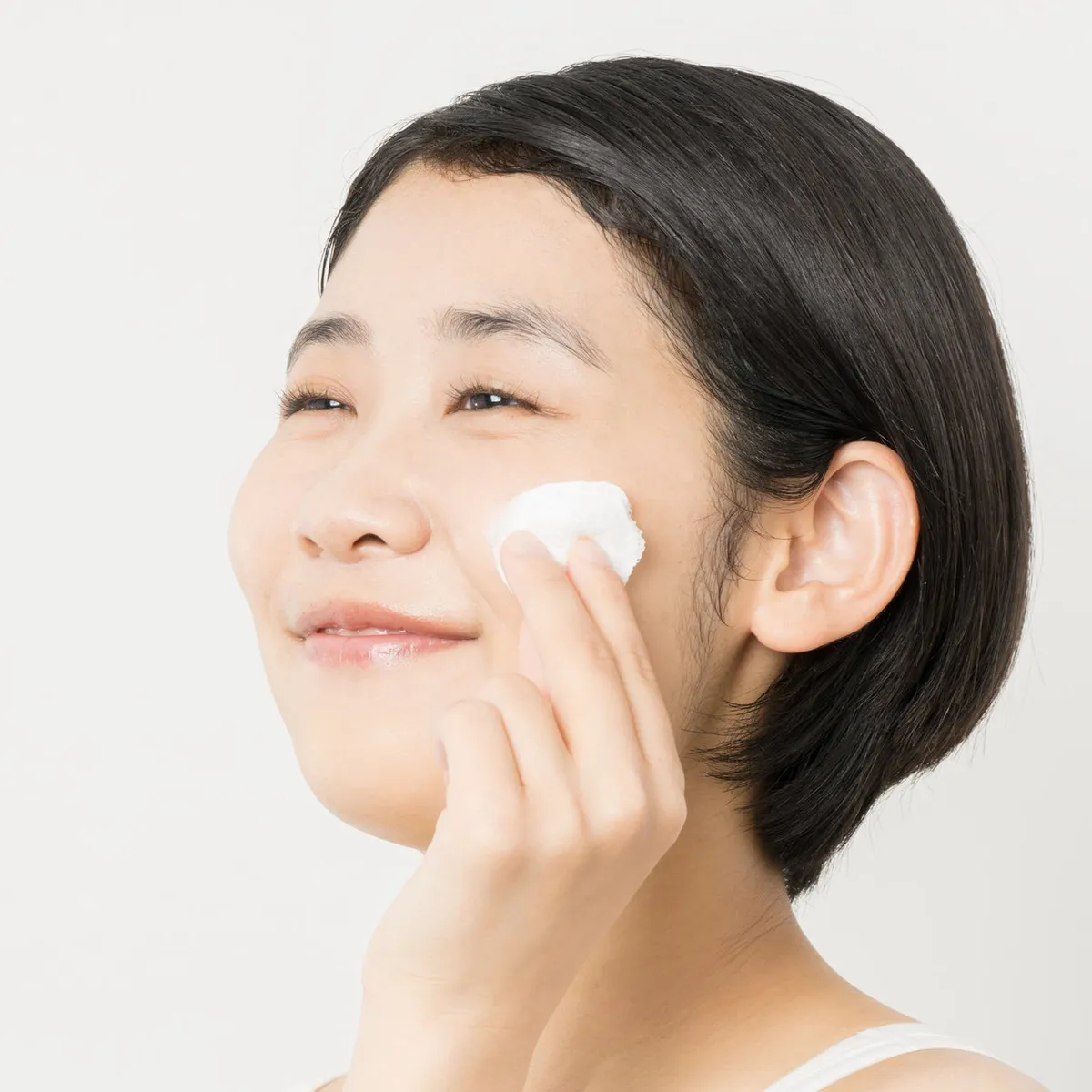 冷たいコットンを頬に当ててケアする様子